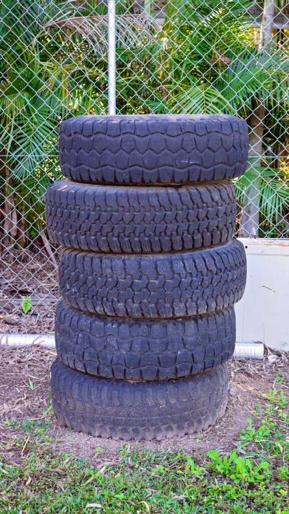 Stack of old car tires, highlighting the need for tire removal and recycling services.