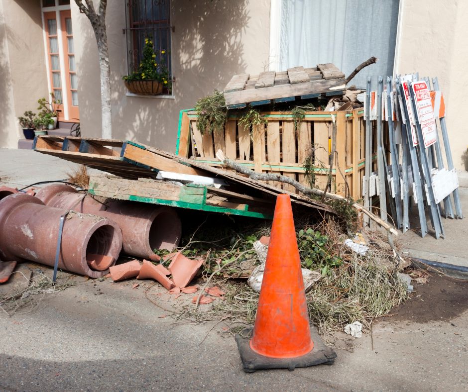 Pile of construction debris and waste materials on the sidewalk, highlighting the need for construction junk removal services